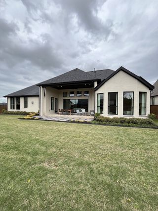 Street view A modern home with a spacious patio and manicured lawn in Mustang Lakes by Tradition Homes (Celina, TX).