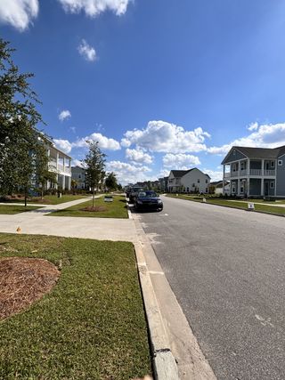 A charming neighborhood street with modern homes and green lawns in Carnes Crossroads by Lennar (Summerville, SC).