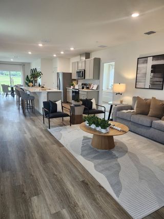 An elegant open-concept living space featuring sleek flooring, modern kitchen, and cozy seating area with stylish decor.