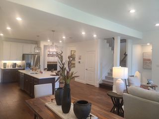 An open-plan living space with a modern kitchen, elegant lighting, and cozy seating enhances this inviting interior.