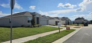 Street view A row of stylish single-family homes with manicured lawns in Leela Reserve by Park Square Residential, showcasing modern architecture.