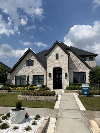 A charming stone and brick home with lush landscaping in Cross Creek West 45' by Perry Homes (Fulshear, TX).