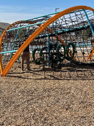 A modern playground with a colorful climbing structure in Tirreno at IronWing by Beazer Homes (Litchfield Park, AZ).