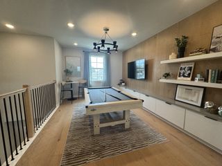 A modern game room featuring a sleek pool table, open shelving, and elegant decor under stylish lighting.