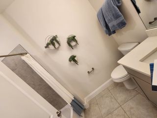 A charming bathroom with soft neutral tones, sleek cabinetry, and elegant greenery adding a fresh, natural touch.