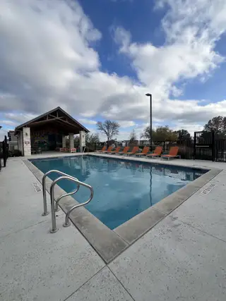 A refreshing community pool with lounge seating, perfect for relaxing and enjoying sunny days in Village on Cooper Lane (Austin, TX).
