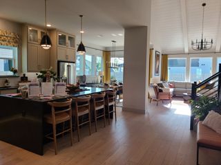 Model Home A modern kitchen and living area with a large island, pendant lights, and ample natural light.