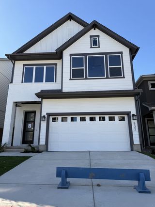 A modern two-story home with crisp white siding and dark trim in Double Creek Crossing – Craftsman Series by David Weekley Homes (Round Rock, TX).