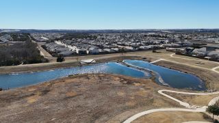 A serene aerial view of Orchard Ridge by CastleRock Communities showcasing scenic trails and ponds in Liberty Hill, TX.