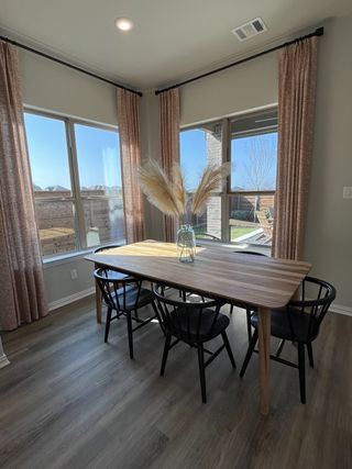 Model Home A bright breakfast nook with large windows, modern decor, and cozy seating in Solterra by Chesmar Homes (Mesquite, TX).