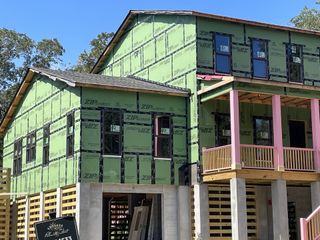 Street view A modern home under construction with green sheathing in Enclave at Palmetto Fort by Homes by Dickerson (Mount Pleasant, SC).