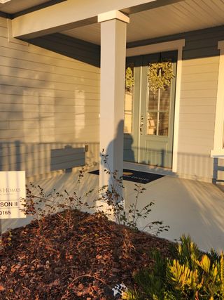Street view A welcoming front porch with elegant siding and a glass door in Hyland Trail by Dream Finders Homes (Green Cove Springs, FL).