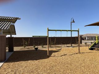 A welcoming playground with swings and shade structures in El Rancho Santa Rosa by Centex (Maricopa, AZ).