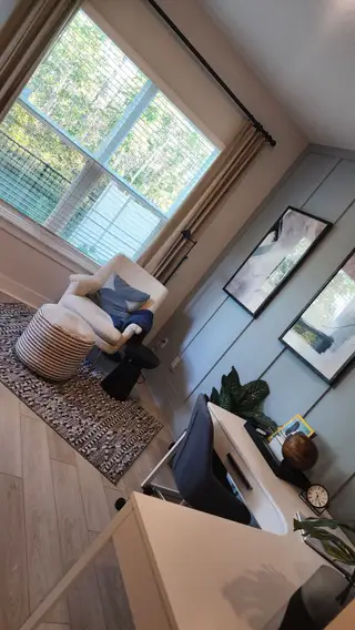 A chic workspace featuring a large window, modern desk, and a cozy reading nook, perfect for productivity and relaxation.