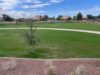 Scenic green park with a walking path in Arroyo Vista II by KB Home, Casa Grande, AZ.
