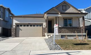 A charming modern home with stone accents and a tidy yard in Settler’s Crossing by Richmond American Homes (Commerce City, CO).