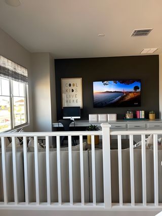 Model Home A modern living space featuring a cozy couch, sleek black accent wall, and stylish décor with natural light streaming in.
