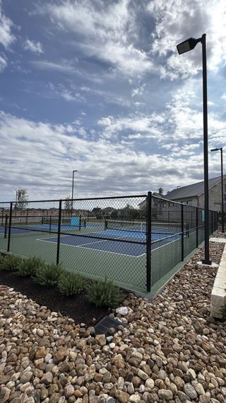 Community Amenities A well-maintained tennis court with lush landscaping in Santa Rita Ranch – Augustine by Sitterle Homes (Liberty Hill, TX).