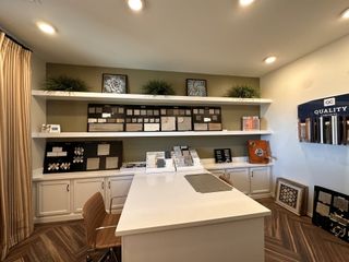 A modern design studio with elegant tile samples, sleek white cabinets, and warm wood flooring.