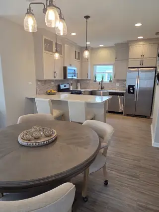 A contemporary kitchen with pendant lights, sleek cabinetry, and a cozy dining table.