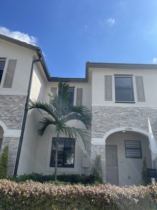 A modern stone-accented home with lush landscaping in Siena Reserve: Del Mesa Collection by Lennar (Miami, FL).