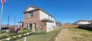 Charming brick-and-siding home with lush landscaping in Abbott Place by Legend Homes (St. Hedwig, TX).