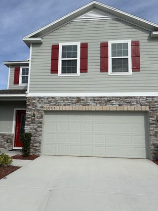 A charming home with red shutters and stone accents in Central Park by Maronda Homes (Port St. Lucie, FL).