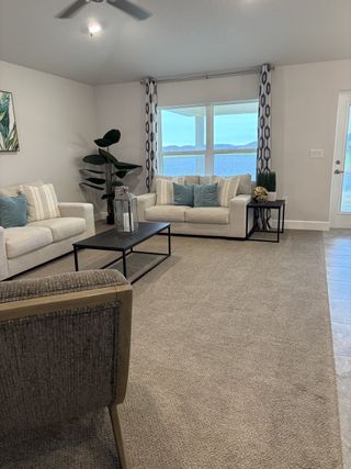 A cozy living room with neutral sofas, elegant curtains, and chic decor.
