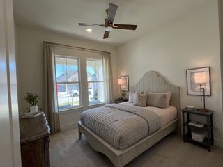 Model Home Cozy bedroom with a neutral palette, elegant bed, and natural light streaming through large windows. Perfect for relaxation.