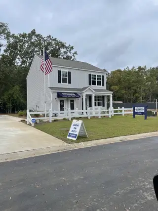 A charming grey two-story home with a welcoming porch in Back River Bend by D.R. Horton (Goose Creek, SC).