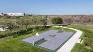 Community Amenities A recreational basketball court surrounded by greenery in Mustang Valley by KB Home (Manor, TX).