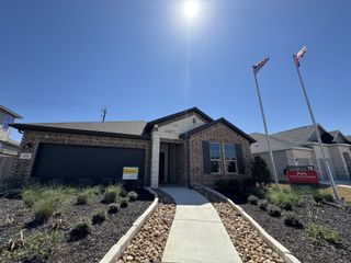 A charming brick home with a manicured yard in Saddle Creek Ranch by HistoryMaker Homes (Cibolo, TX).