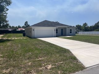 A charming single-story home with a spacious driveway and manicured lawn in Marion Oaks by Zephyr Homes (Ocala, FL).