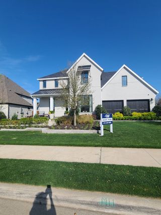 Street view A modern white home with elegant details and lush landscaping in Star Trail - 65s by American Legend Homes (Prosper, TX).