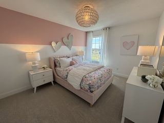 A pink-themed bedroom featuring heart-shaped wall decor, a blush bed frame, and soft lighting for a cozy retreat.