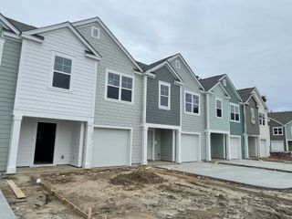 Street view Charming row of townhomes displaying pastel exteriors in The Townes at Merrimack by D.R. Horton (Moncks Corner, SC).