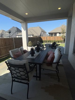 An inviting covered patio with stylish outdoor seating and a cozy dining area.