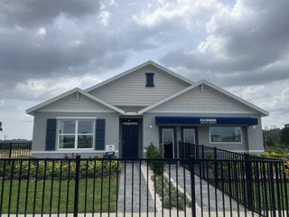 A charming single-story model home in Summit View by D.R. Horton (Dade City, FL) featuring a gray exterior, blue accents, and a landscaped front yard.