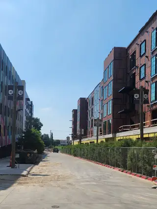 Wide shot of the developing Congress Lofts Saint Elmo with vibrant colors and scaffolding, showing progress of the construction by Intracorp (Austin, TX).