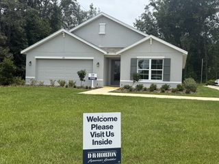 Charming gray home with shutters and a lush yard in Marion County Spot Lots by D.R. Horton (Ocala, FL).