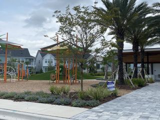 Community Amenities A vibrant community park with a modern playground and lush landscaping in Granville at eTown 38' by David Weekley Homes (Jacksonville, FL).