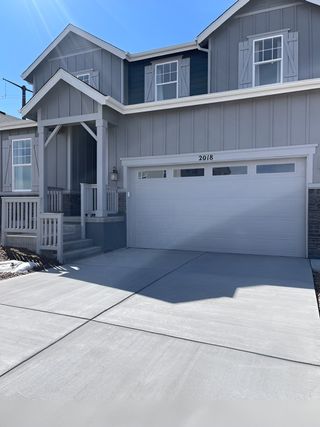 A charming gray home with shutters and a spacious driveway in Terrain Oak Valley by KB Home (Castle Rock, CO).