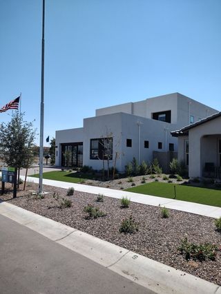 Street view A modern white home with sleek lines and a landscaped yard in Ascent at Avalon Crossing by Shea Homes (Mesa, AZ).