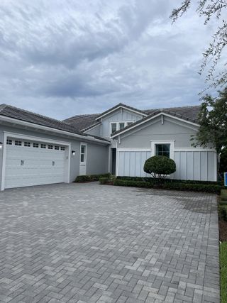 A modern gray home with a spacious driveway in Westlake by Minto Communities (Westlake, FL).