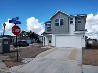 Street view A modern two-story home with a sleek facade and ample garage in The Enclave at Hidden Oaks by Williams Homes (Georgetown, TX).