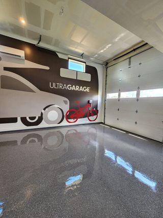 A sleek garage with glossy floors, modern wall art, and ample space for storage. Ideal for innovative home projects.