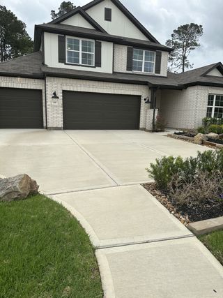 A charming brick home with dark shutters and a three-car garage in Moran Ranch by M/I Homes (Willis, TX).