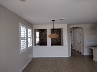Model Home An elegant room with wood-like flooring, sleek light fixture, neutral walls, and stylish window shutters for a modern look.