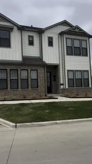 A modern home with brick and siding in Collin Creek by Ashton Woods (Plano, TX).