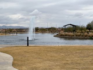 A serene pond with a central fountain and lush surroundings in Laurel at Blossom Rock by Brookfield Residential (Apache Junction, AZ).